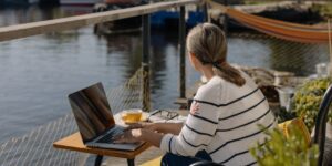 Femme habillée en pull marin et travaillant sur son ordinateur